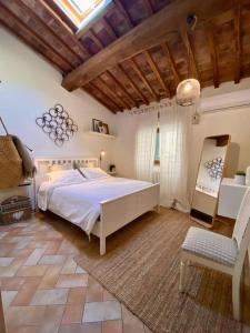 een slaapkamer met een wit bed en een houten plafond bij Locanda Il Sigillo B&B e Ristorante in Rosignano Marittimo