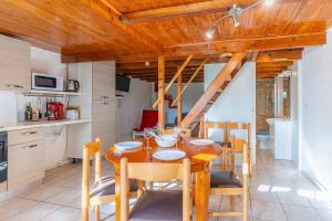 eine Küche und ein Esszimmer mit einem Holztisch und Stühlen in der Unterkunft Duplex en residence tennis piscine in Naujac-sur-Mer