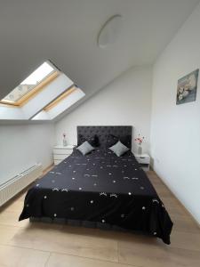 a bedroom with a black bed in a white room at Fericirii A in Cluj-Napoca