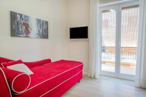 een rode bank in een woonkamer met een raam bij Gemma di Zagara Apartment in Sorrento
