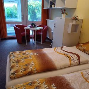 a bed in a room with a table and chairs at Pension Mark in Hoyerswerda
