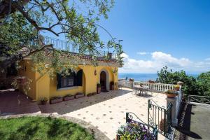ein gelbes Haus mit Balkon und Meerblick in der Unterkunft Villa Turtle in Massa Lubrense