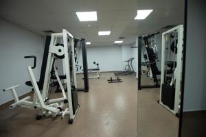 a gym with several tread machines in a room at El Sheikh Suites Hotel in Beirut