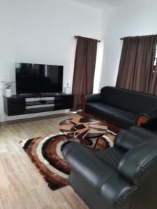 a living room with a couch and a flat screen tv at Samayra's Apartment in Nadi
