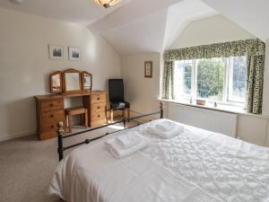 a bedroom with a white bed and a window at 1 Tan Yr Ywen in Conwy