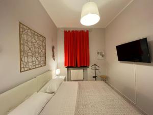Camera con tenda rossa e TV di La Borasca - Apartments a Casalpusterlengo