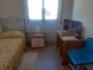 1 dormitorio con cama, escritorio y silla en I Paoletti apartment!, en Quartu SantʼElena
