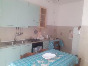 una pequeña cocina con mesa y fregadero en I Paoletti apartment! en Quartu SantʼElena