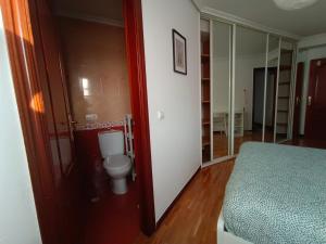a bathroom with a toilet and a bed in a room at El Portazgo Restaurante Hostal La Cisterniga in La Cistérniga