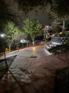 una strada di città di notte con alberi e un marciapiede di SweetHome a Monterrey