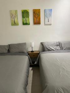 two beds in a bedroom with paintings on the wall at SweetHome in Monterrey