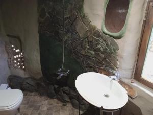 Baño de piedra con lavabo y aseo en Casa Madre en Villa Yacanto