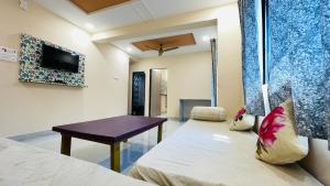 a room with a bed and a table and a tv at Devka House HomeStay in Daman