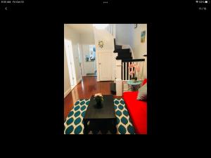 Gateway en-suite bedroom next jhu في بالتيمور: غرفة معيشة مع أريكة حمراء وطاولة