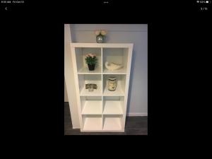 Gateway en-suite bedroom next jhu في بالتيمور: رف كتاب أبيض مع زرع خزاف عليه