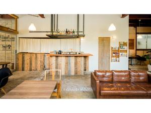 a living room with a couch and a table at fan! -ABURATSU- Sports Bar & HOSTEL - Vacation STAY 78427v in Nichinan