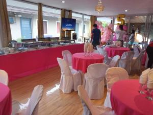 a room with pink tables and chairs and a buffet at Central Perk inspired pool villa in Bacolod