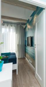 Cette chambre comprend un lit et une télévision murale. dans l'établissement Apartament MUSZELKA na Solnej 11 z garażem, à Kołobrzeg