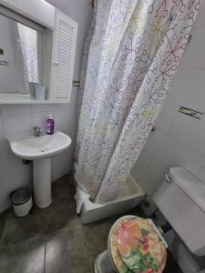 a bathroom with a sink and a shower curtain at Vista al Mar Departamento - Edificio Acapulco in Viña del Mar
