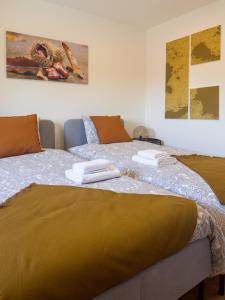 una camera da letto con due letti con asciugamani sopra di Casa do Souto - Nature & Experiences - Turismo Rural a Bragança Altre 64 foto