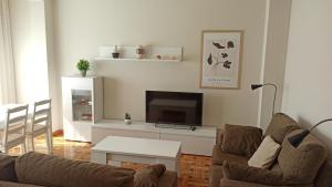 ein Wohnzimmer mit einem Sofa und einem Flachbild-TV in der Unterkunft El Torreón in Soria