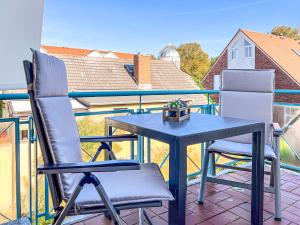 Una mesa y dos sillas en un balcón. en Haus am Teich Wohnung 21, en Boltenhagen