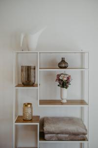 a white shelf with a vase of flowers on it at Villa SEEhnsucht in Jois