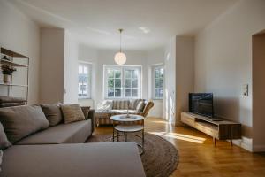 a living room with a couch and a tv at Villa SEEhnsucht Ferienwohnungen in Jois