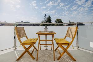 two chairs and a table on a balcony at Villa SEEhnsucht Ferienwohnungen in Jois
