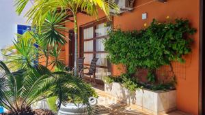 a building with plants on the side of it at Casa Tropical Com Piscina por Quarto à Vista in Lagoa do Mato