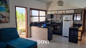 a kitchen with a white refrigerator and a counter at Casa Tropical Com Piscina por Quarto à Vista in Lagoa do Mato