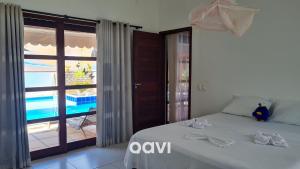 a bedroom with a bed with a view of a pool at Casa Tropical Com Piscina por Quarto à Vista in Lagoa do Mato +25 photos