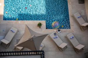 an overhead view of a pool with chairs and an umbrella at 49 Sunrise Lodge in Għajnsielem