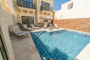 a swimming pool in front of a building at 49 Sunrise Lodge in Għajnsielem
