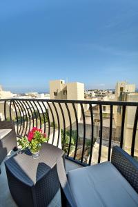 a balcony with a table and chairs with a view at 49 Sunrise Lodge in Għajnsielem