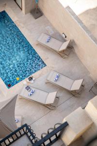 an overhead view of a swimming pool with tables and chairs at 49 Sunrise Lodge in Għajnsielem