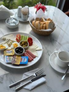 a table with two plates of food and a basket of bread at Asgard Hotel in Beylikduzu