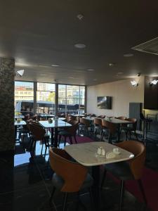 a dining room with tables and chairs and windows at Asgard Hotel in Beylikduzu