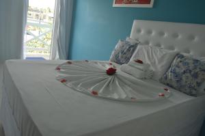 a white bed with a plate on top of it at Pousada Vovó Zilda Maragogi in Maragogi