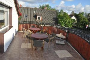 a patio with tables and chairs and a fence at Central Łeba Suites in Łeba
