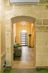 a living room with a stone wall and a couch at 49 Sunrise Lodge in Għajnsielem