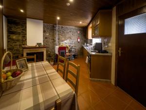 una cucina e una sala da pranzo con tavolo e cesto di frutta di Casa do Souto - Nature & Experiences - Turismo Rural a Bragança