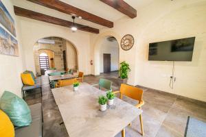 a living room with a table and chairs and a tv at 49 Sunrise Lodge in Għajnsielem