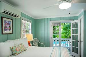 um quarto com uma cama branca e paredes verdes em Westwinds Inn em Key West