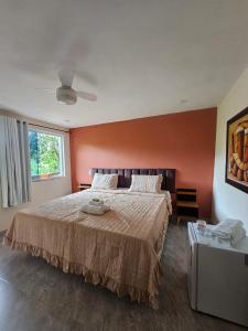 um quarto com uma cama grande e uma parede laranja em Hotel Pousada Bambuzal em Sana mais 37 fotografias