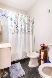 a bathroom with a toilet and a shower curtain at Vivi la mejor experiencia en el corazon de BA !!!! in Buenos Aires