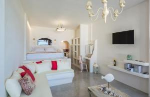 a living room with a white couch and a bed at Black Diamond Suites in Akrotiri