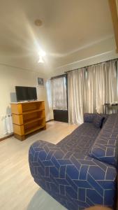 um quarto com uma cama azul e uma cómoda em Hotel Tissiani Canela em Canela
