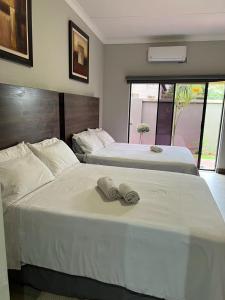 Dos camas en una habitación de hotel con toallas. en KB Guesthouse en Groblersdal