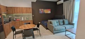 cocina y sala de estar con mesa y sofá. en H&W Sunway Onsen Suites Services Tambun Ipoh S-07-05 en Ipoh